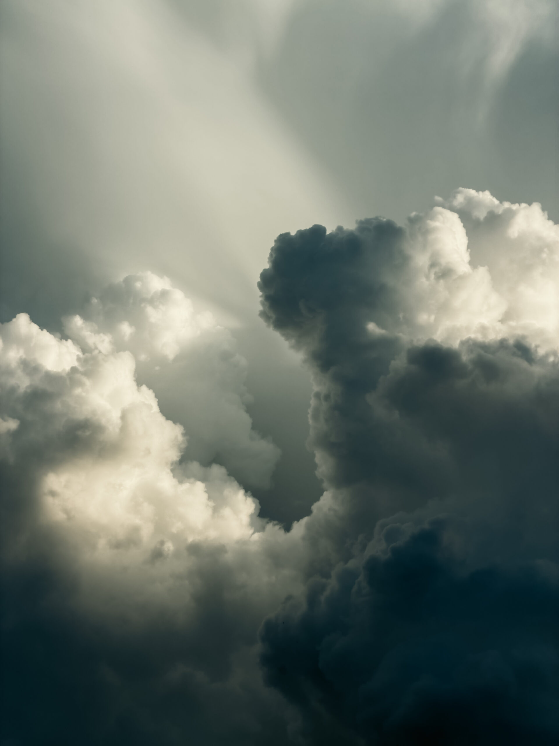Black and white fine art photograph of dramatic clouds rising into the sky
